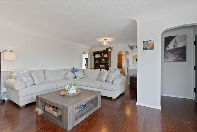 living room featuring a textured ceiling and dark hardwood / wood-style flooring