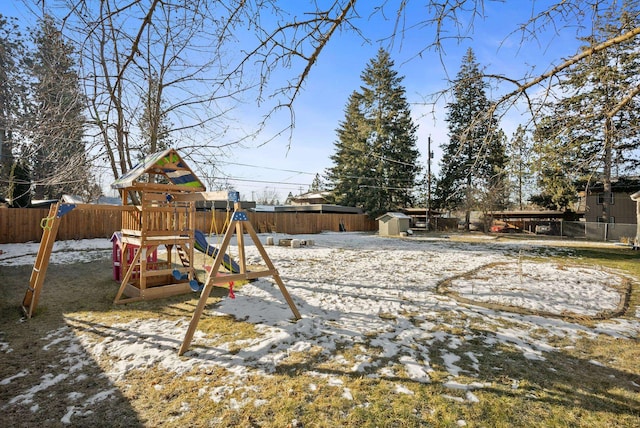 snow covered playground featuring a shed