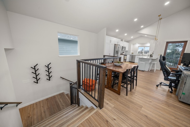 dining space featuring vaulted ceiling and light hardwood / wood-style flooring