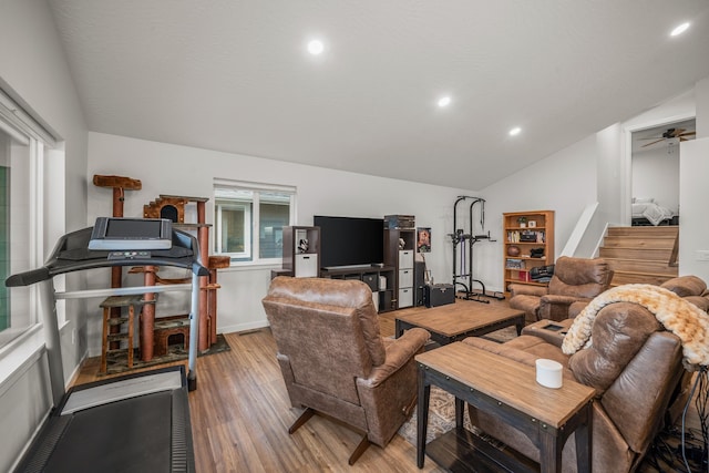 living room with hardwood / wood-style flooring, vaulted ceiling, and ceiling fan