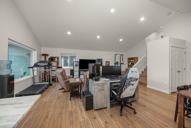 office space with high vaulted ceiling and light wood-type flooring