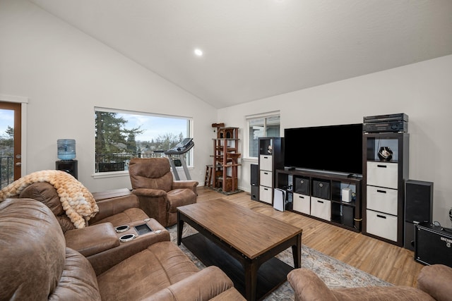 living room featuring high vaulted ceiling and light wood-type flooring