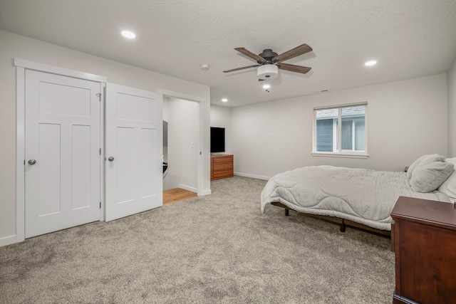 carpeted bedroom featuring a textured ceiling and ceiling fan