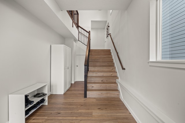 stairway featuring hardwood / wood-style flooring and a high ceiling