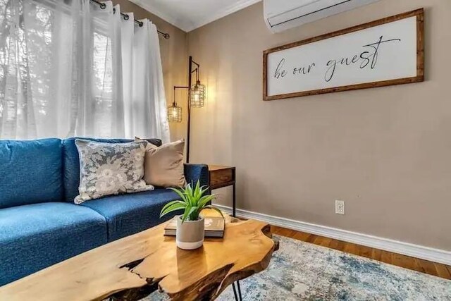 sitting room with hardwood / wood-style flooring and a wall unit AC