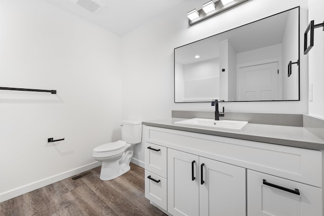 bathroom with wood-type flooring, vanity, and toilet