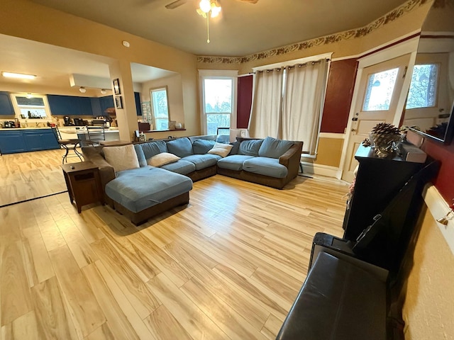 living room featuring ceiling fan and light hardwood / wood-style floors