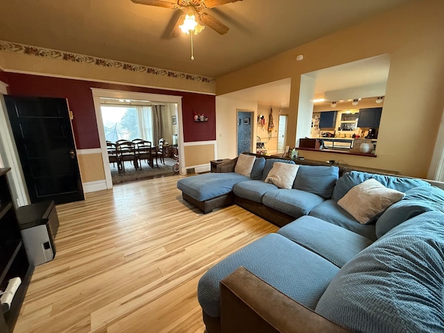 living room featuring ceiling fan and light wood-type flooring