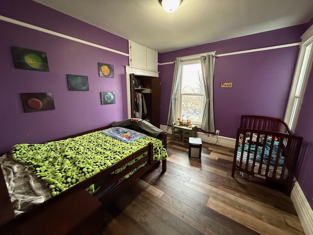 bedroom featuring dark hardwood / wood-style flooring and a closet