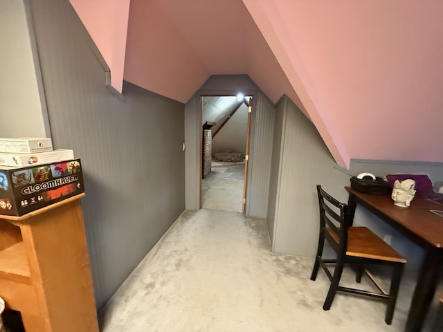 interior space with vaulted ceiling and light colored carpet