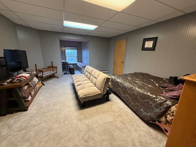 carpeted bedroom with a baseboard radiator and a drop ceiling