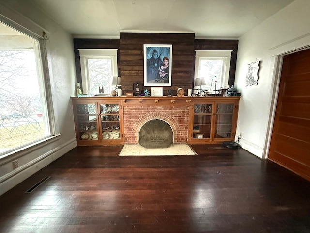 living room with plenty of natural light, dark hardwood / wood-style floors, and a fireplace