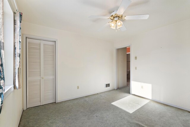 unfurnished bedroom with carpet, ceiling fan, and a closet