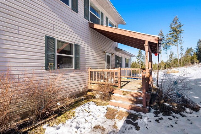 view of snowy exterior featuring a wooden deck