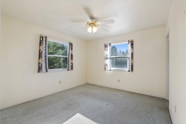 carpeted empty room featuring ceiling fan