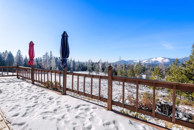 snow covered deck with a mountain view