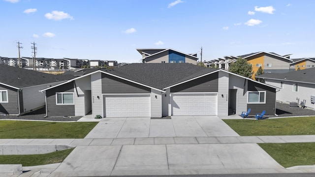 view of front of property featuring a residential view, a front lawn, and a garage