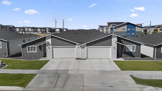 view of front of home featuring a front yard, a garage, a residential view, and concrete driveway