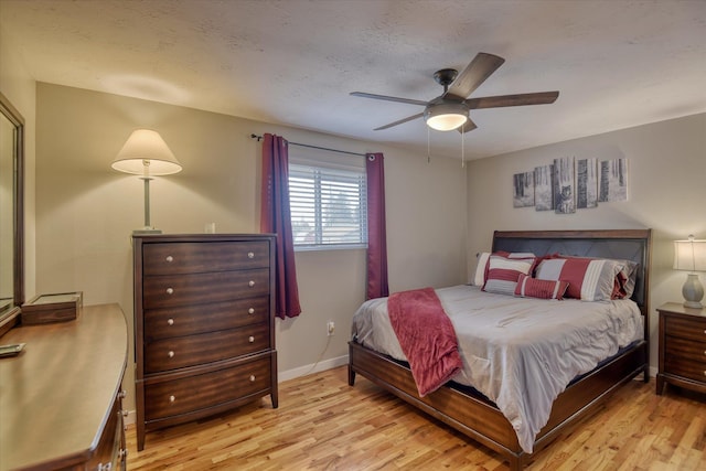 bedroom with ceiling fan, light hardwood / wood-style floors, and a textured ceiling