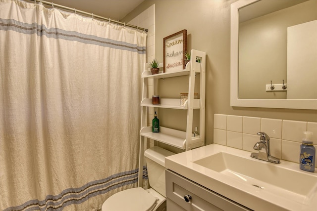 bathroom with toilet, vanity, and decorative backsplash