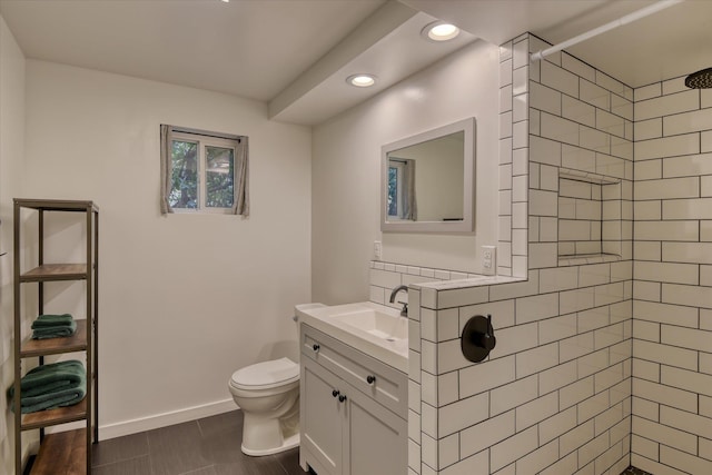 bathroom featuring vanity, tiled shower, and toilet