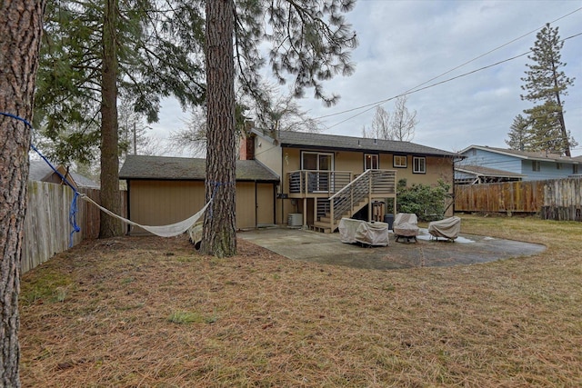 back of property with a patio, a yard, and a wooden deck