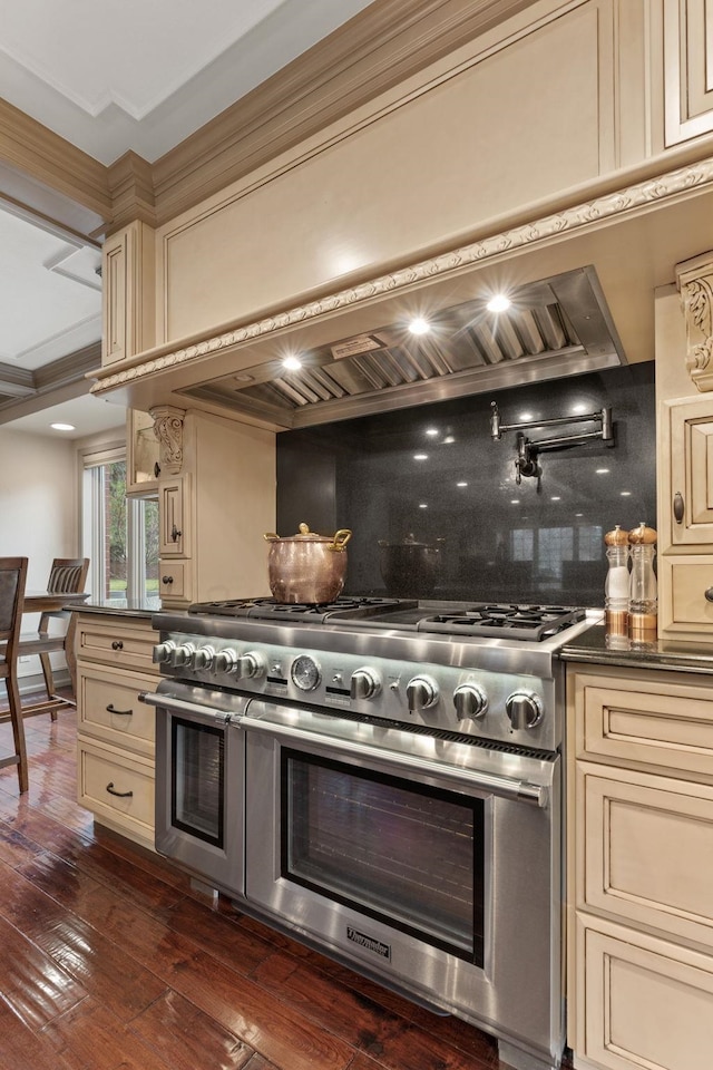 kitchen featuring range with two ovens, cream cabinets, dark wood-type flooring, and decorative backsplash