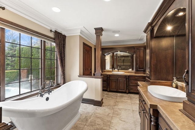 bathroom featuring ornate columns, a tub to relax in, vanity, and ornamental molding