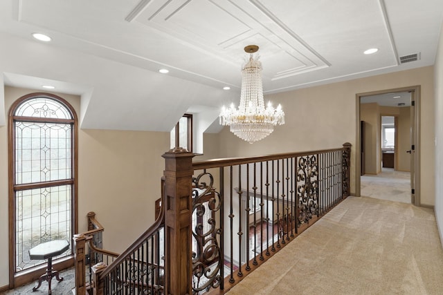 hall featuring light colored carpet and a chandelier