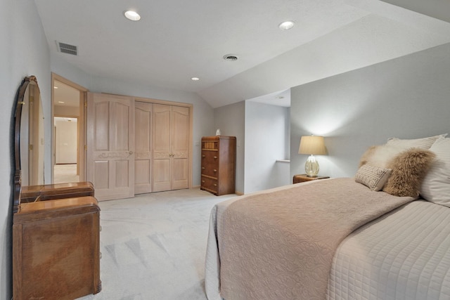 carpeted bedroom featuring vaulted ceiling and a closet