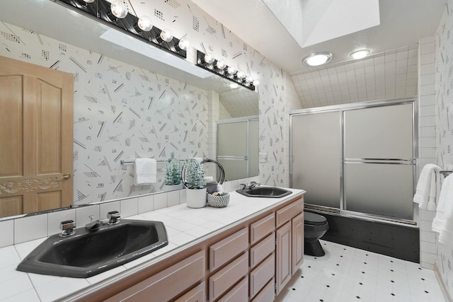 full bathroom featuring enclosed tub / shower combo, vanity, toilet, and a skylight