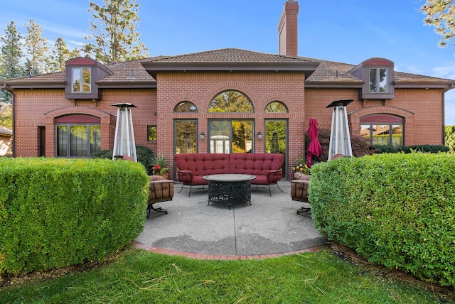 back of house featuring an outdoor living space and a patio area