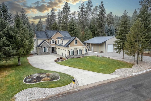 view of front of property featuring a garage, an outdoor structure, and a lawn