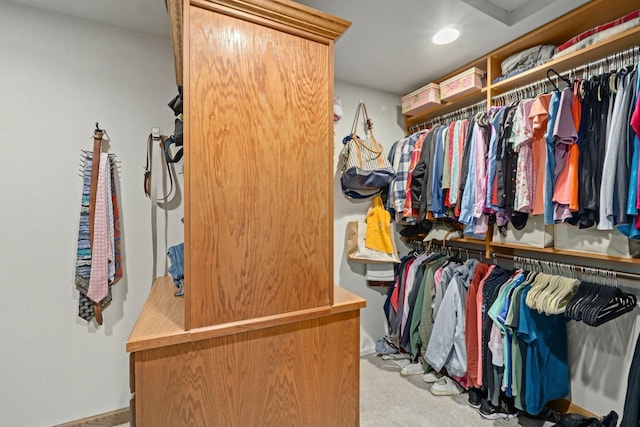walk in closet featuring light carpet