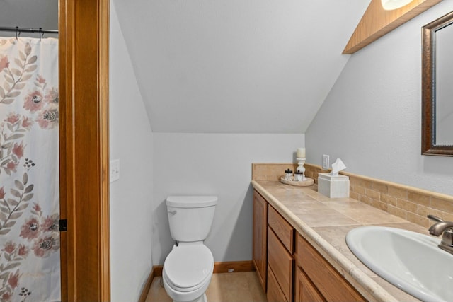 bathroom featuring vanity, lofted ceiling, and toilet