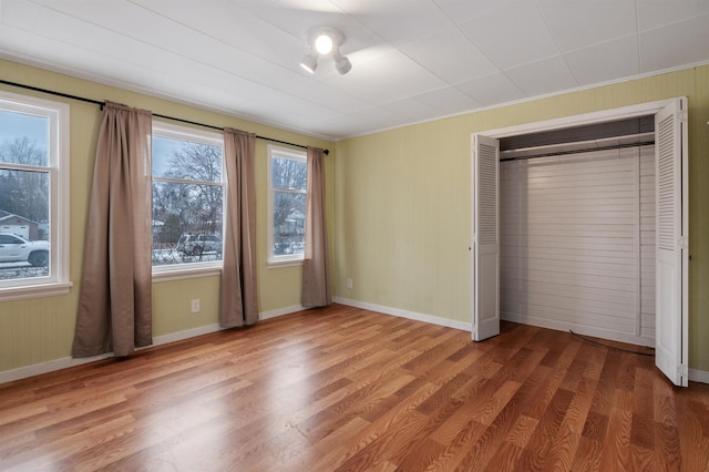 unfurnished bedroom featuring wood-type flooring and a closet