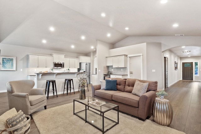 living room featuring lofted ceiling and light hardwood / wood-style flooring