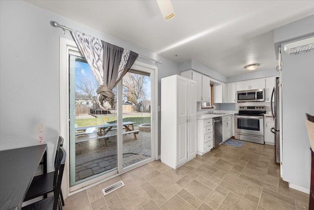 kitchen featuring stainless steel appliances, sink, and white cabinets