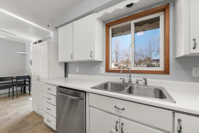 kitchen featuring stainless steel dishwasher, sink, and white cabinets