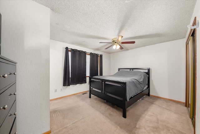 carpeted bedroom with ceiling fan and a textured ceiling