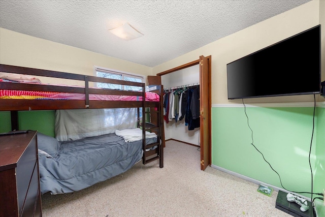 carpeted bedroom with a spacious closet, a closet, and a textured ceiling