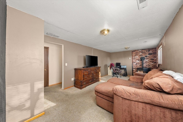 carpeted living room featuring a wood stove and a textured ceiling