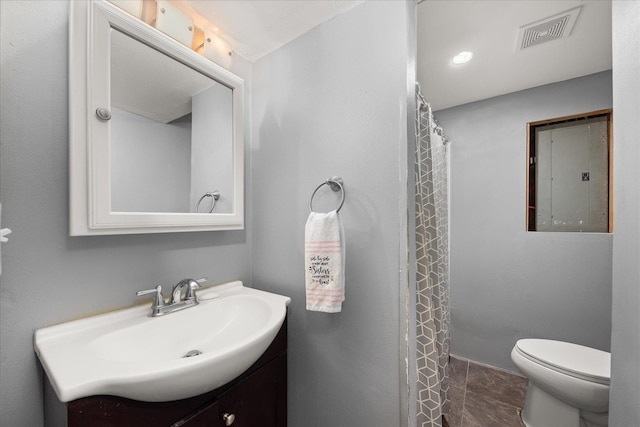 bathroom featuring vanity, toilet, and electric panel