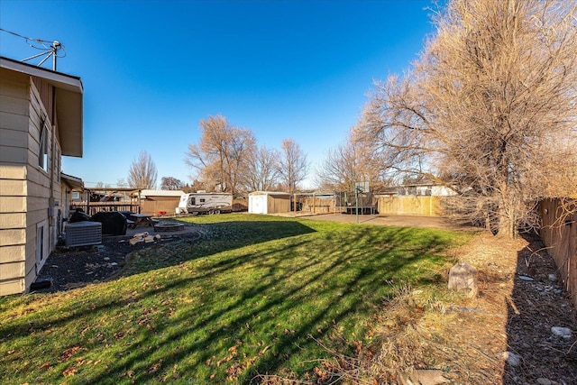 view of yard with central AC and a storage unit