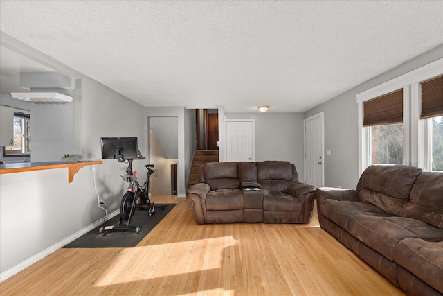 living room with a healthy amount of sunlight, a textured ceiling, and light hardwood / wood-style flooring