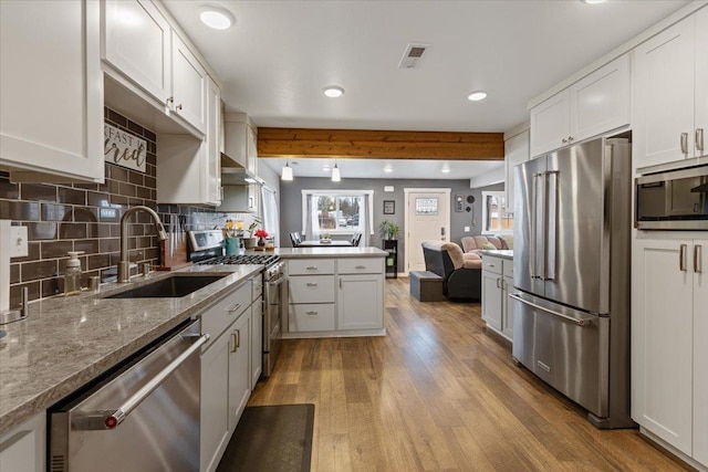 kitchen featuring sink, white cabinets, kitchen peninsula, stainless steel appliances, and light hardwood / wood-style flooring