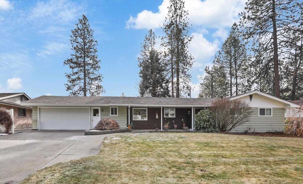 ranch-style home featuring a garage and a front lawn