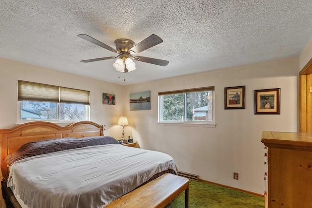 carpeted bedroom featuring ceiling fan and a textured ceiling