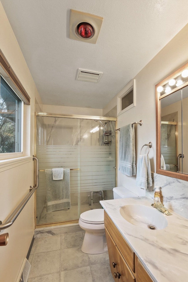 bathroom featuring toilet, an enclosed shower, a textured ceiling, vanity, and tile patterned flooring