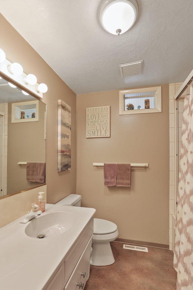 bathroom with vanity, a textured ceiling, and toilet